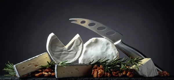 Vari formaggi a pasta molle con noci e rosmarino . — Foto Stock