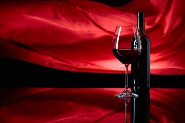 Винное Стекло Бутылка Красного Вина Черном Отражающем Фоне Красный Атласный — стоковое фото