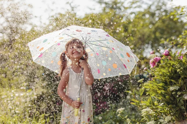 Mutlu Küçük Kız Bahçede Yaz Yağmuru Altında Bir Şemsiye Ile — Stok fotoğraf