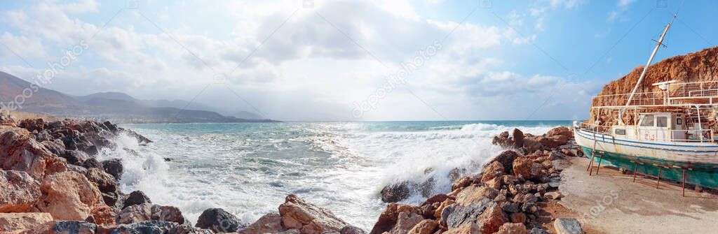 Old abandoned ship on the beach. Storm on a summer day in the Mediterranean. Panorama of the Mediterranean sea, Greece.