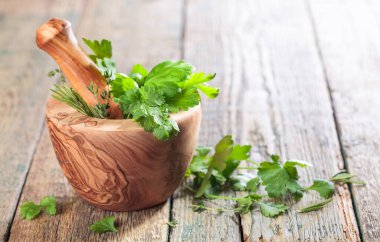 Biberiye, kişniş, kekik ve maydanozlu ahşap havan..