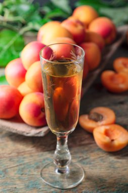 Kayısı likörü veya şarap ve ahşap bir masada sulu meyveler..