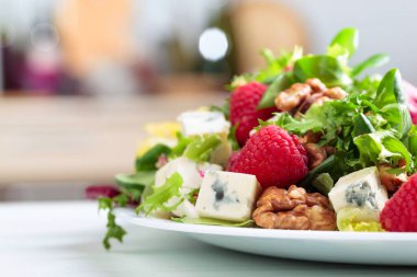 Yeşil yaz salatası, otlar, mavi peynir, ahududu ve ceviz. Lezzetli sağlıklı yemek..