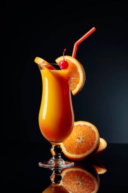 Tequila Sunrise cocktail with orange and cherry on a black reflective background. clipart