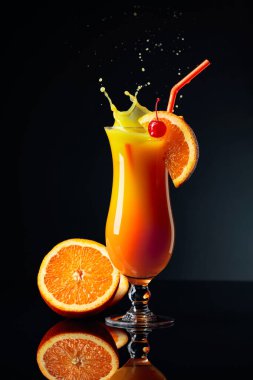 Siyah yansıtıcı arka planda turuncu ve kirazlı tekila Sunrise kokteyli.