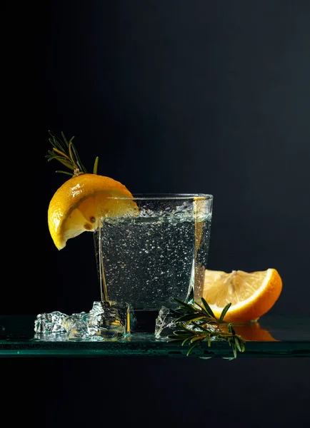 Gin Koktajlowy Cytryną Rozmarynem Napój Gazowany Kawałkami Lodu Szklanym Stole — Zdjęcie stockowe