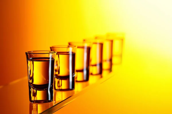 Wódka Żółtym Tle Mocny Napój Alkoholowy Małych Kieliszkach — Zdjęcie stockowe