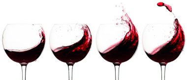 Beyaz arka planda izole edilmiş bir bardakta kırmızı şarap damlaları.