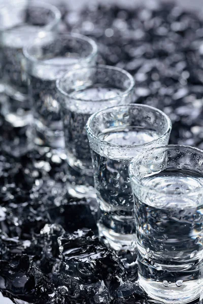 Bicchieri Umidi Vodka Con Ghiaccio Uno Sfondo Riflettente Nero Focus — Foto Stock