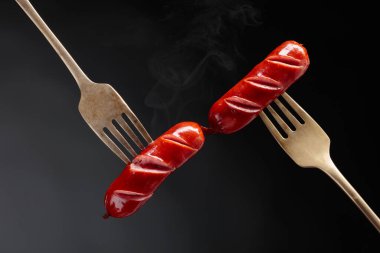 Çatalda ızgara sosis. Siyah arkaplan, boşluğu kopyala. 