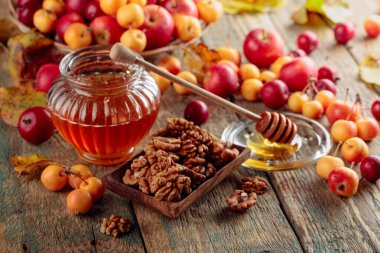 Red and yellow crab apples with honey and walnuts, healthy organic food. clipart