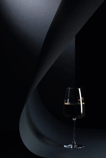 Glass of white wine on a black background. Copy space.