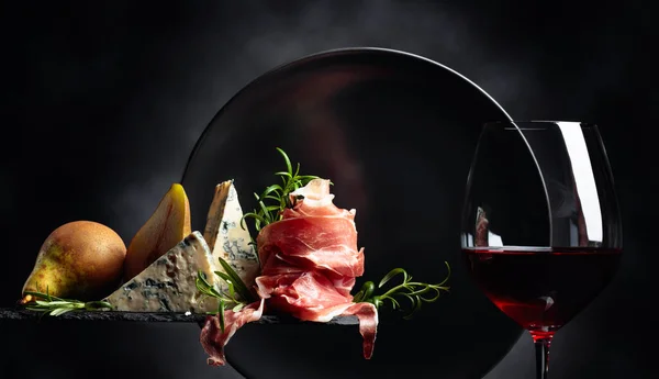 伝統的な地中海の軽食と赤ワインのグラス 青いチーズ ローズマリーのプロシュットまたはスペインのジャモン — ストック写真