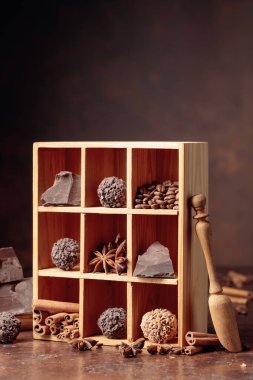 Çikolatalı trüf, kırık çikolata ve baharatlı. Çikolata, tarçın çubukları, anason ve kahve çekirdekleri tahta kutuda.. 