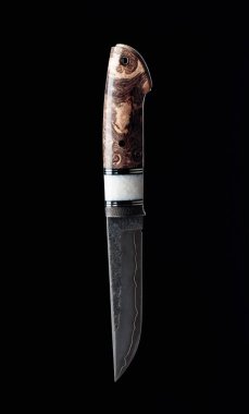 Avcı el yapımı siyah bir arka planda bıçak. Bıçağın yüzeyi - oyma, dövülme izleri. Sapı - yerleştirilmiş akrister, Japon akçaağacı.
