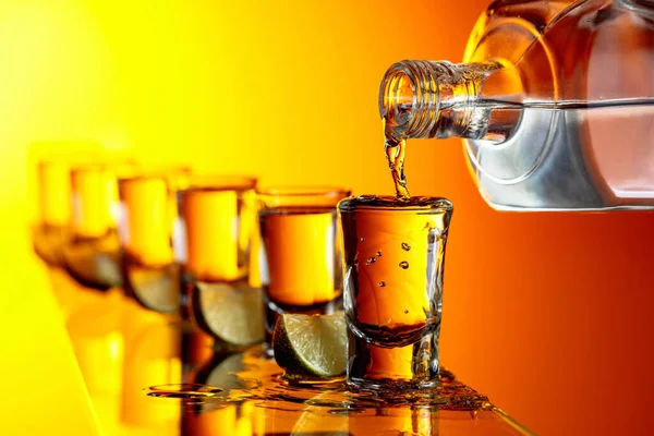 Pouring Strong Alcoholic Drink Small Glasses Tequila Lime Slices Yellow — Stock Photo, Image