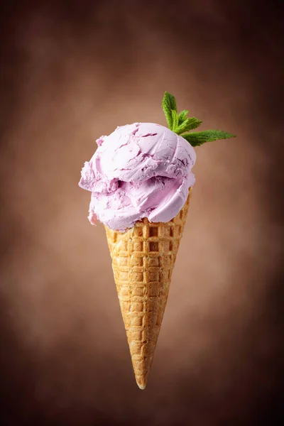 ワッフルコーンにミント入りブルーベリーアイス 茶色の背景にアイスクリーム — ストック写真