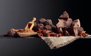 Çikolata, tarçın çubukları ve koyu bir arka planda anason. Boşluğu kopyala.