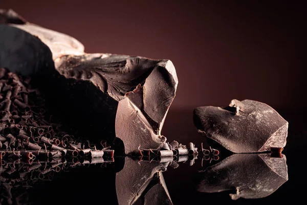 Pezzi Cioccolato Fondente Amaro Gocce Cioccolato Uno Sfondo Nero Riflettente — Foto Stock