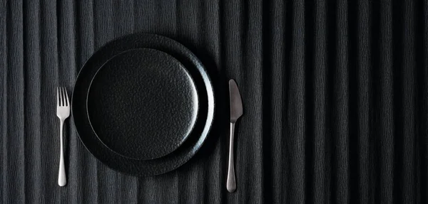Пустая Черная Тарелка Вилка Нож Черном Фоне Вид Сверху Пространство — стоковое фото