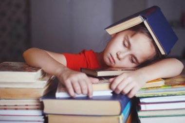 kitap yığınları ile uyuyan kız