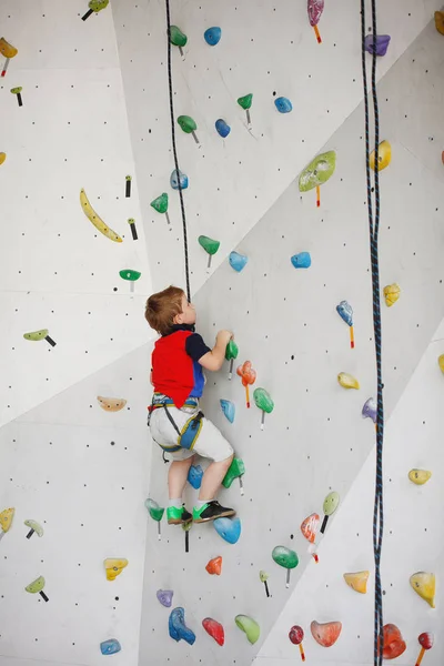 Niño escalando en una pared alta — Foto de Stock