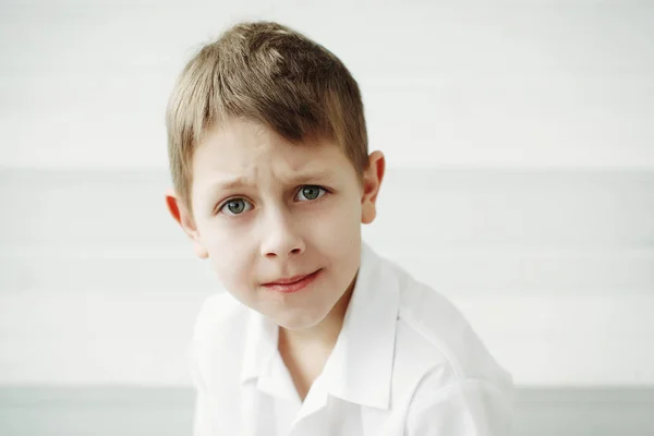 Porträtt allvarlig pojke i en vit skjorta. — Stockfoto