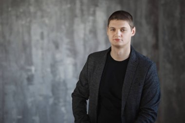 Stüdyoda bir gri ceketli genç adam.