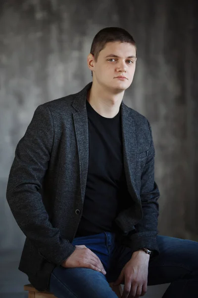 Joven con una chaqueta gris en el estudio . —  Fotos de Stock