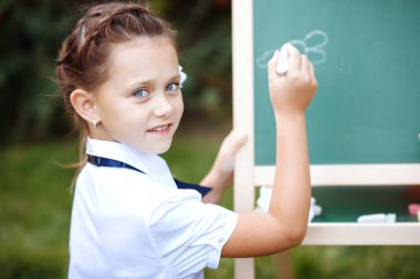 Parkta yazı tahtası ile kız öğrenci.