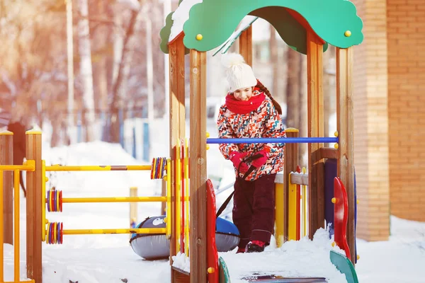 Boldog kis lány játszik a téli játszótér — Stock Fotó