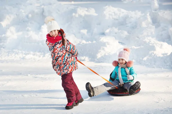 Happy little Girls slidding snow tubing — Stock Photo, Image