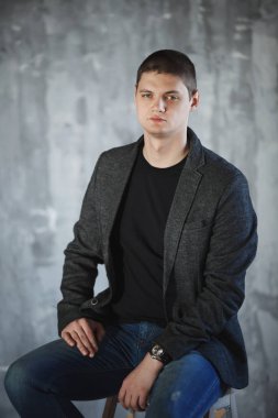 Stüdyoda bir gri ceketli genç adam.