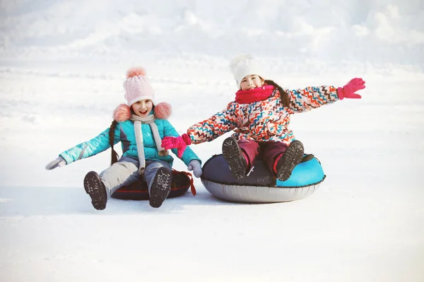 Glada lilla flickor skjutbara snö slangar — Stockfoto