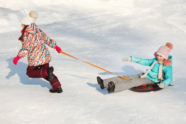 Happy little Girls posuvné snowtubing — Stock fotografie