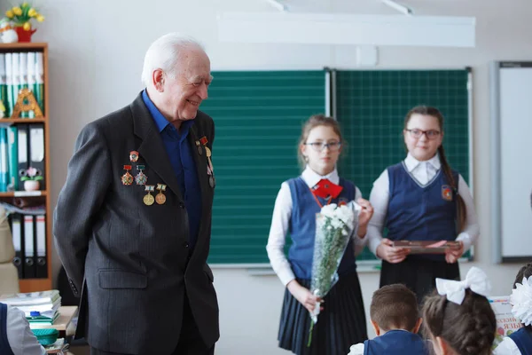 Ein russischer Veteran erzählt den Kindern in der Schulklasse vom Krieg. Russland. nowosibirsk. Februar 2018 — Stockfoto