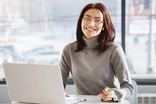 Бізнес-леді в офісі сидить і працює з ноутбуком — стокове фото