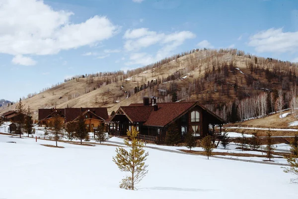 Casa de madera en invierno en el Altai o montañas alpinas — Foto de Stock