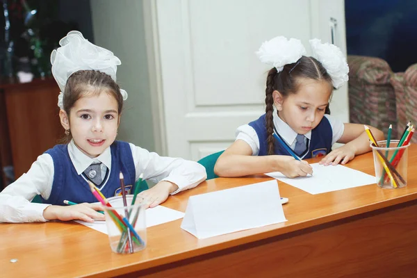 Zwei konzentrierte kleine Mädchen zeichnen am Tisch auf Papier — Stockfoto