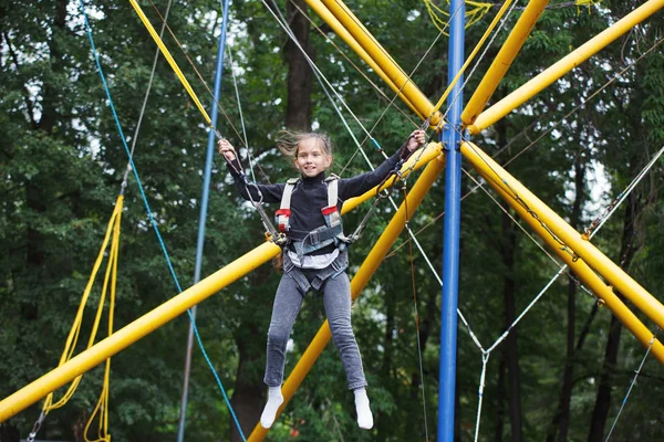 Chica joven jugando en el trampolín bungee — Foto de Stock