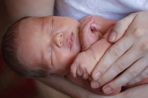 Sleeping baby in mom\'s hands