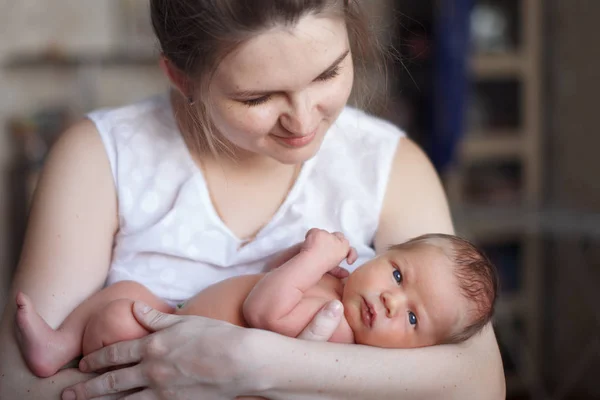 Pretty woman holding a newborn baby in her arms — Stock Photo, Image