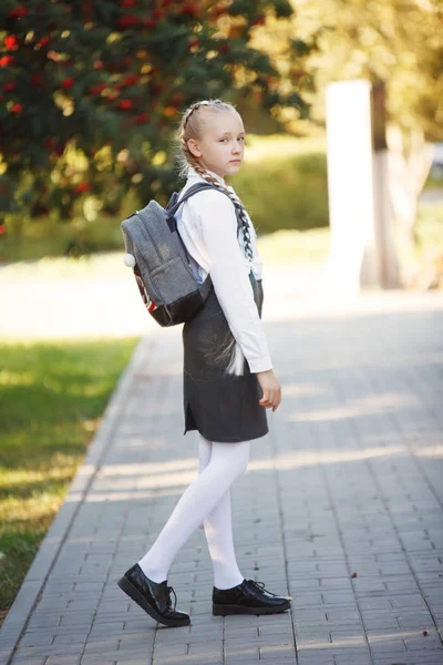 Симпатичная девочка в парке по дороге в школу — стоковое фото
