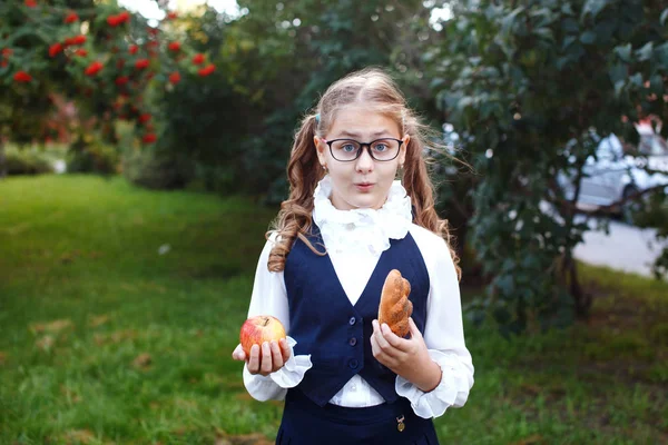 Bir genç kızın tatlı rulo ve ne yemek seçme elma tutar — Stok fotoğraf