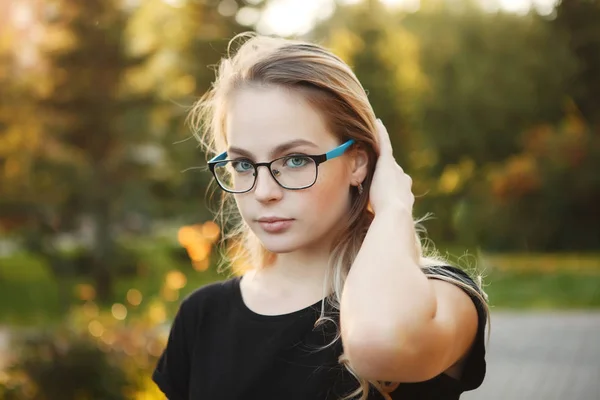 Beautiful woman in glasses on a autumn yellow background closeup — Stock Photo, Image