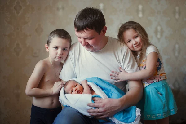 Padre con tre figli sta tenendo un bambino tra le braccia — Foto Stock