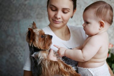 Güzel genç anne yorkshire köpek ve gülümseyerek yürümeye başlayan çocuk ile bir