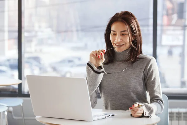 Бізнес-леді в офісі сидить і працює з ноутбуком — стокове фото