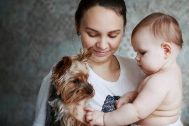 Güzel genç anne yorkshire köpek ve gülümseyerek yürümeye başlayan çocuk ile bir