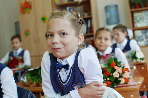 Schöne Schulkind an einem Schreibtisch im Urlaub. Ausbildung in der Grundschule — Stockfoto